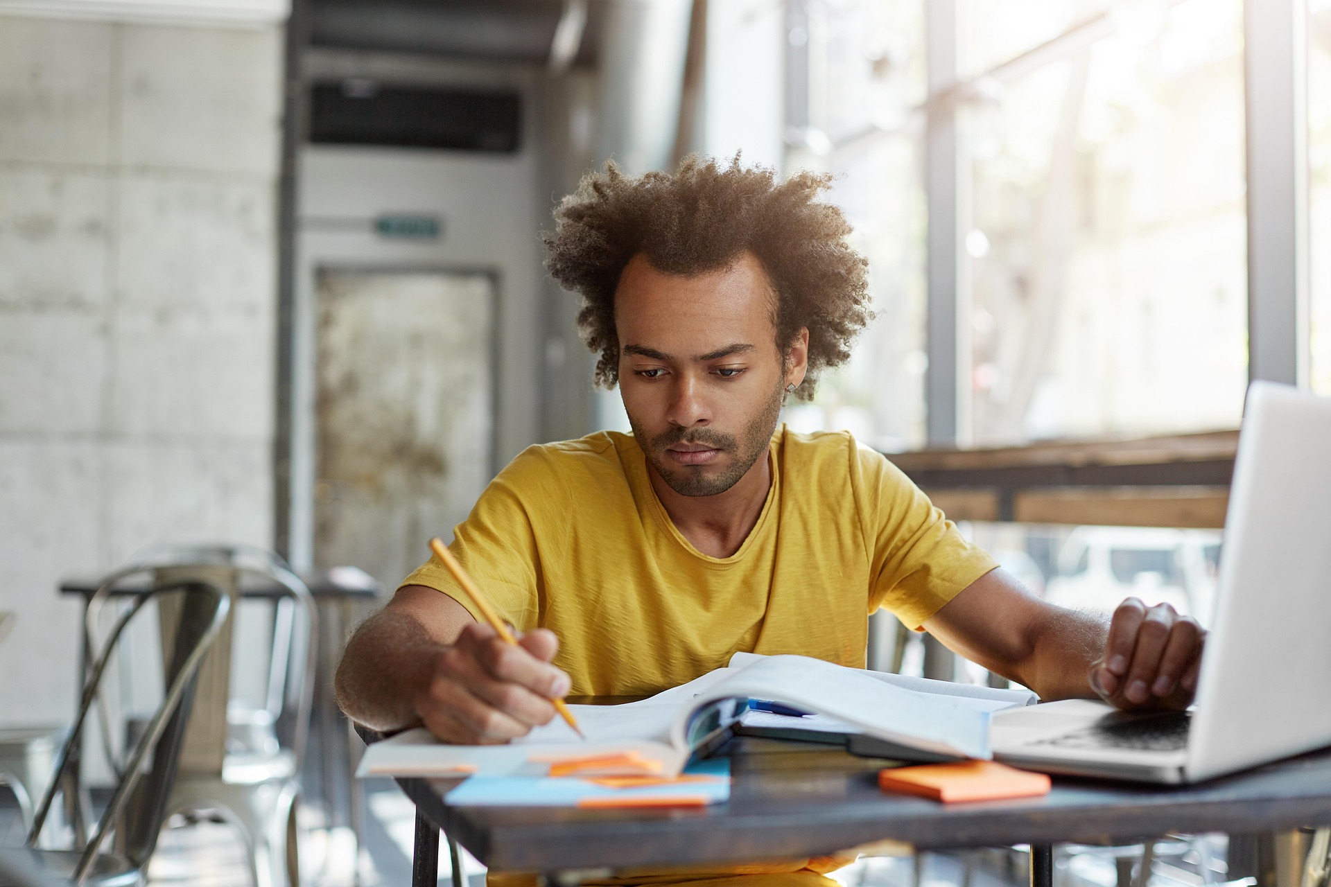 Persona trabajando de noche en un escritorio de taller con planos en el portátil
